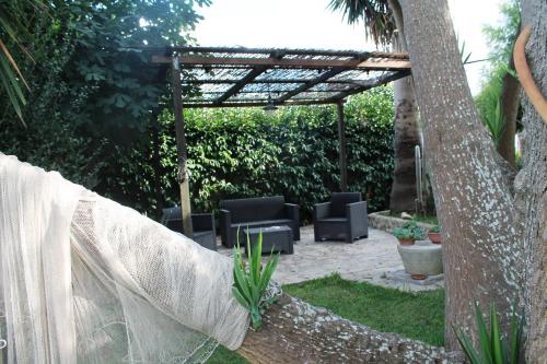 a backyard with a pergola and chairs and a tree at TERRA DI MARE LOC. TURISTICA in Vignacastrisi