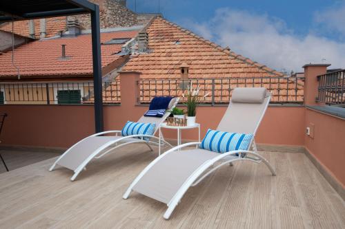 two chairs and a table on a balcony at Attico Belvedere - Terrazza Vista Mare con Barbecue e Jacuzzi Privata in Ceriale