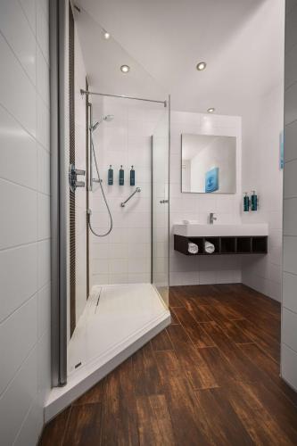 a bathroom with a shower and a sink at Hilton Garden Inn Leiden in Leiden