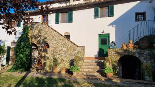 a large white building with a green door at Borgo San Michele Incisa Tuscany in Incisa in Valdarno
