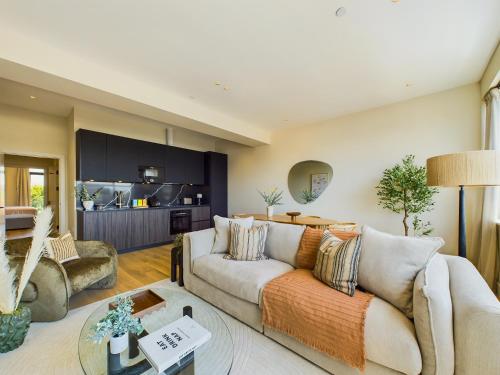 a living room with a couch and a table at Be London - The St Pancras Residences in London