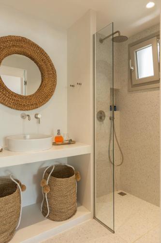a bathroom with a shower and a sink and a mirror at Perivoli Rooms in Parikia