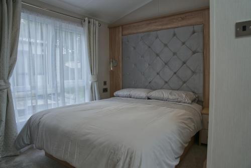 a bedroom with a large bed with a large window at Castle Archdale Holiday Park in Enniskillen