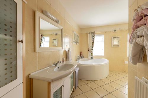 a bathroom with a tub and a sink and a bath tub at Mountain Nest at the foot of Slieve Gullion in Cloghoge