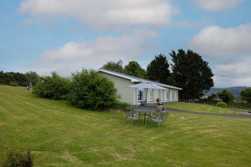 a house with a table and chairs in a yard at Mountain Nest at the foot of Slieve Gullion in Cloghoge