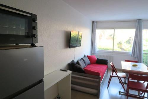 - un salon avec un canapé et un fauteuil rouge dans l'établissement Grand studio lumineux Boulouris, plage 5min à pied, à Saint-Raphaël