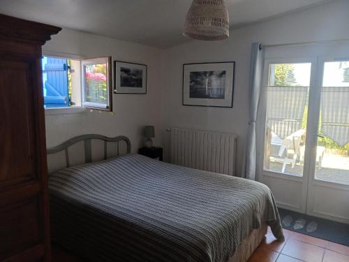 a bedroom with a bed and a sliding glass door at Ty Glaz in Kerbors
