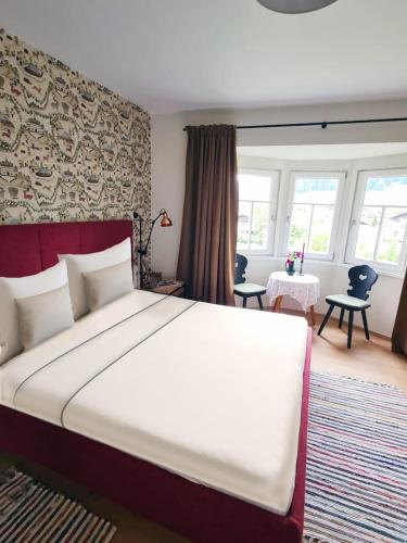 a bedroom with a large bed in a room with windows at Landhaus Antonia in Bruck an der Großglocknerstraße