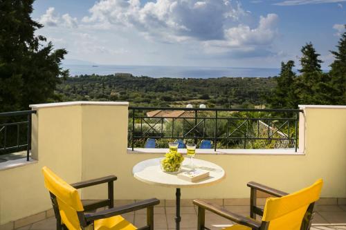 a table and chairs on a balcony with a view at Thalia Villas in Trapezaki