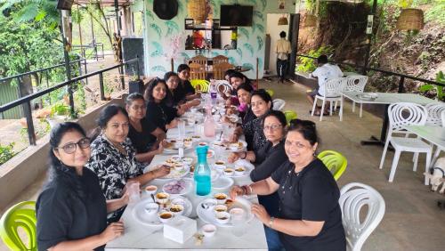 a group of people sitting at a table eating food at The Wai Hills MTDC Approved in Wai