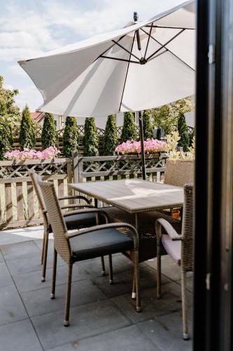 a table and chairs with an umbrella on a patio at Dobre Kąty całoroczne domki in Kąty Rybackie