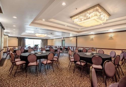 a conference room with tables and chairs and a chandelier at Coast Victoria Hotel & Marina by APA in Victoria