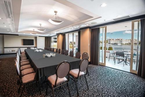 a conference room with a long table and chairs at Coast Victoria Hotel & Marina by APA in Victoria
