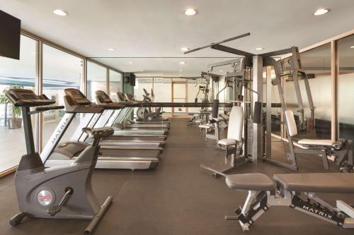 a gym with a row of treadmills and ellipticals at Coast Victoria Hotel & Marina by APA in Victoria