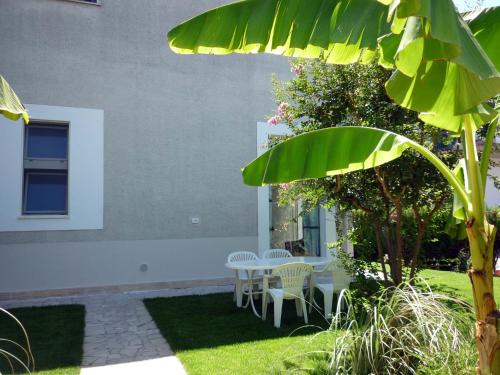 a patio with a table and chairs in a yard at Loft 1-2-3, in centro, con giardino, a 150 m dal mare in Pineto