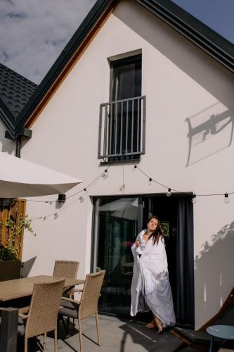 a woman in a wedding dress standing in front of a building at Dobre Kąty całoroczne domki in Kąty Rybackie