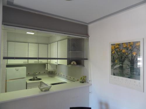 a kitchen with a sink and a large window at Apartamentos Blaumar in L'Estartit