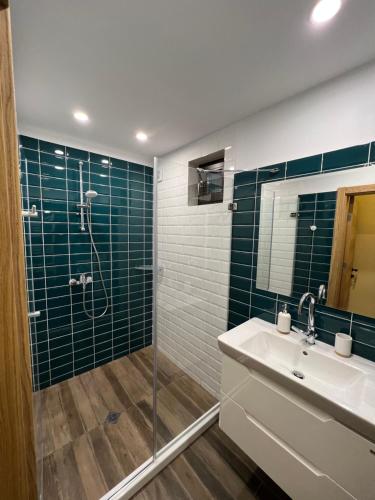 a bathroom with a sink and a shower with green tiles at Villa Alessandra in Emona