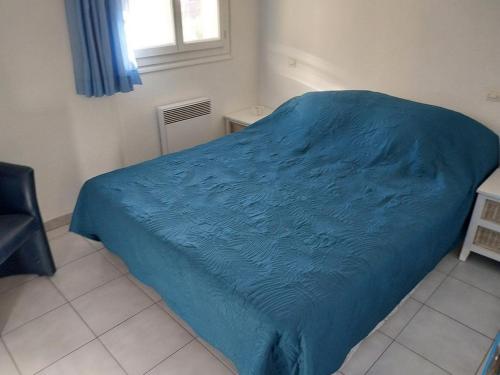 - un lit avec une couverture bleue dans une chambre dans l'établissement les elmes 3, à Banyuls-sur-Mer