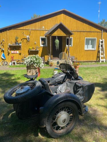 a motorcycle parked in the grass in front of a building at Torgu Royal Guesthouse in Iide