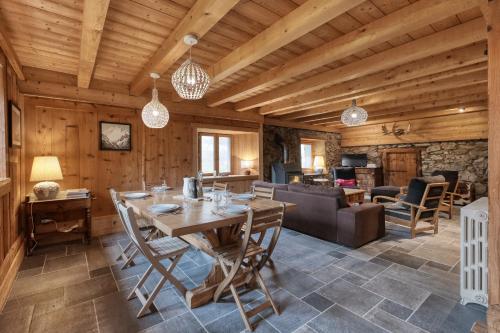 - une salle à manger et un salon avec un plafond en bois dans l'établissement La ferme des ours - sur les pistes, vue Mont-Blanc, à Saint-Gervais-les-Bains
