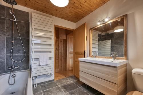 un bagno con vasca, lavandino e doccia di La ferme des ours - sur les pistes, vue Mont-Blanc a Saint-Gervais-les-Bains