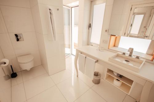 a white bathroom with a sink and a toilet at Palacio Avenida in Palma de Mallorca