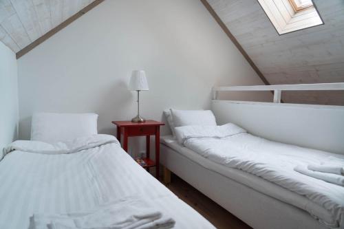two white beds in a room with a window at Kackelstugan in Borgholm