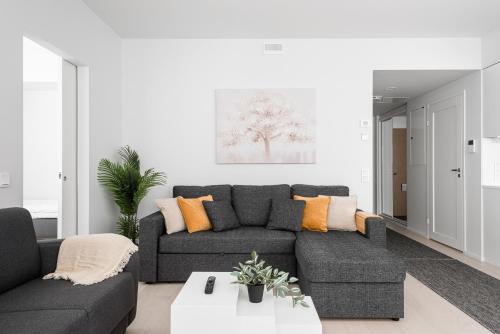 a living room with a gray couch and orange pillows at Borg Katarina - Riverside View in Pori
