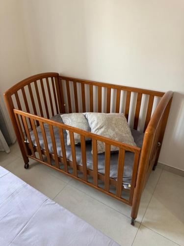 a wooden crib with a pillow in a room at Pompeii Getaway - Scavi di Pompei - Intero appartamento max 6 persone a 5 min dal centro in Scafati