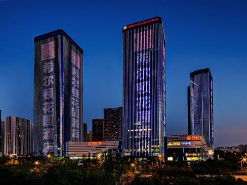 a group of tall buildings in a city at night at Hilton Garden Inn Taiyuan Binhe in Yangjiabu