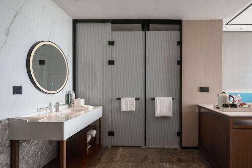 a bathroom with two sinks and a mirror at Hilton Garden Inn Taiyuan Binhe in Yangjiabu