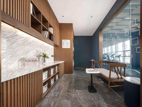 a bathroom with a sink and a tub and a chair at Hilton Garden Inn Taiyuan Binhe in Yangjiabu