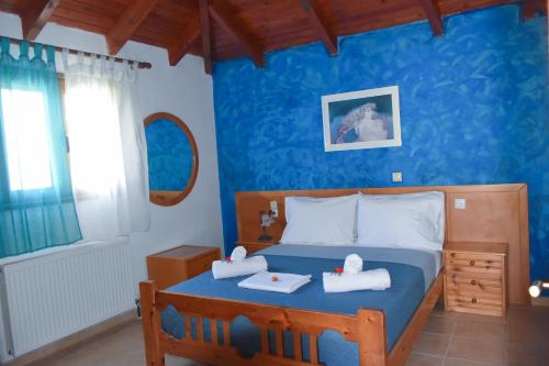 a blue bedroom with a bed with two towels on it at Zaros Traditional House in Zarós