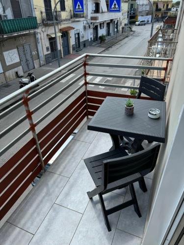 a table and chairs on a balcony with a street at Pompeii Getaway - Scavi di Pompei - Intero appartamento max 6 persone a 5 min dal centro in Scafati