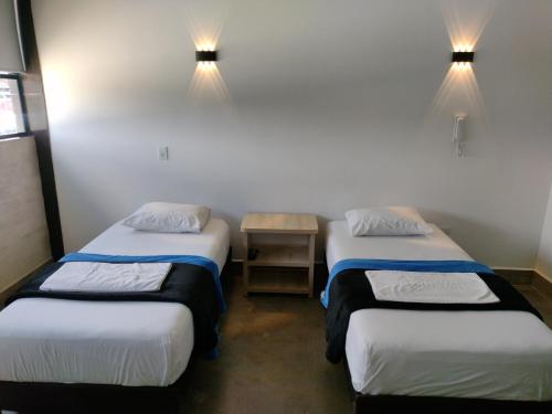two beds in a room with lights on the wall at Hotel El Cordobes in Marinilla