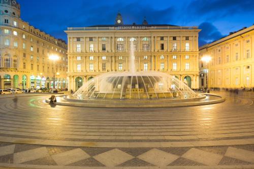 a fountain in front of a building at night at Morali Palace in Genova