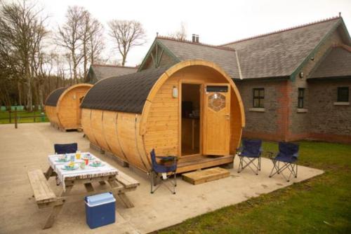 a large wooden house with chairs and a table at Castle Archdale Holiday Park in Enniskillen