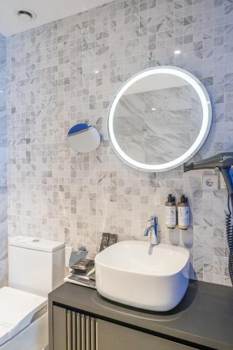a bathroom with a sink and a mirror on a counter at Abba San Sebastián Hotel in Donostia-San Sebastián