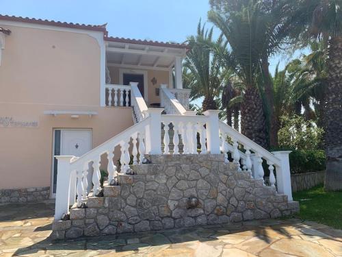 a staircase leading to a house with palm trees at Casa di Stephanie - Petrothalassa - Porto Heli in Kranidi