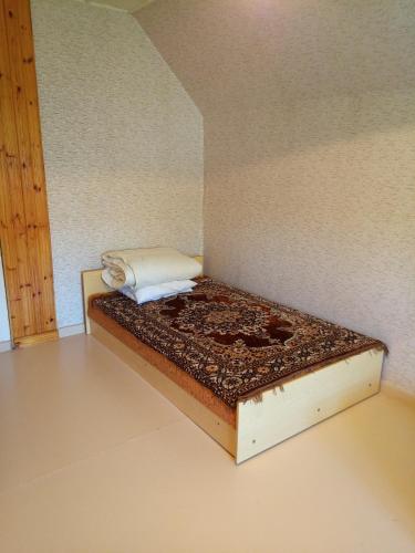 a small bed in a corner of a room at Lohusuu Kortermajutus in Venekyula