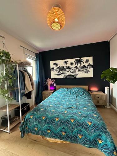 une chambre avec un lit avec une couette bleue dans l'établissement Appartement confortable et parking, à Asnières-sur-Seine