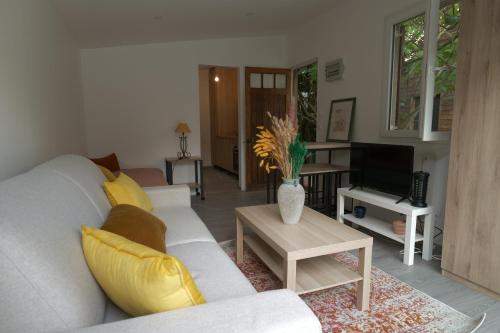 un salon avec un canapé blanc et une télévision dans l'établissement Charmant studio lumineux à Chaville, à Chaville