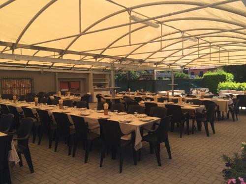 un groupe de tables et de chaises sous une tente dans l'établissement Albergo Cristallo, à Cittiglio