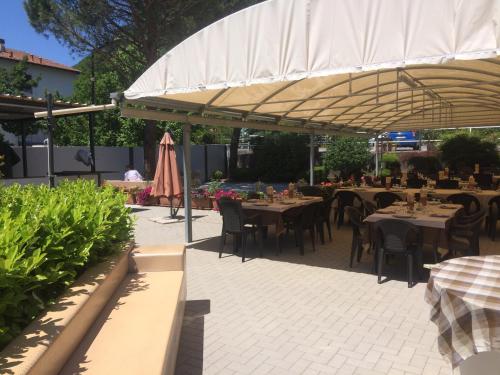 a restaurant with tables and chairs under a canopy at Albergo Cristallo in Cittiglio