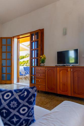 a living room with a tv on a wooden dresser at Nice to stay in Fontane Bianche
