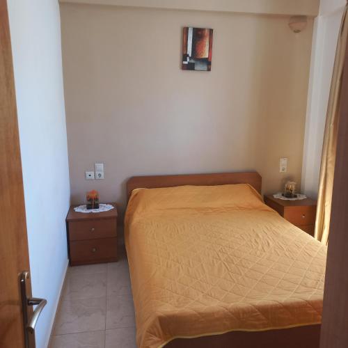 a small bedroom with a bed and two night stands at Central Rooms in Makry Gialos