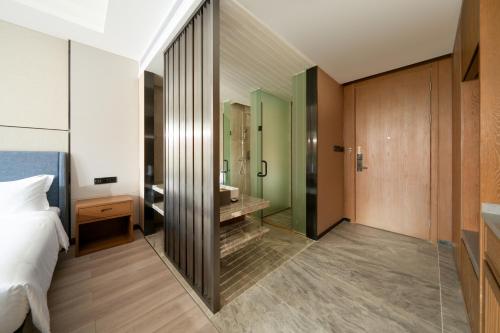 a bedroom with a bathroom with a shower and a bed at DongHu Resort Hotel in Sihanoukville