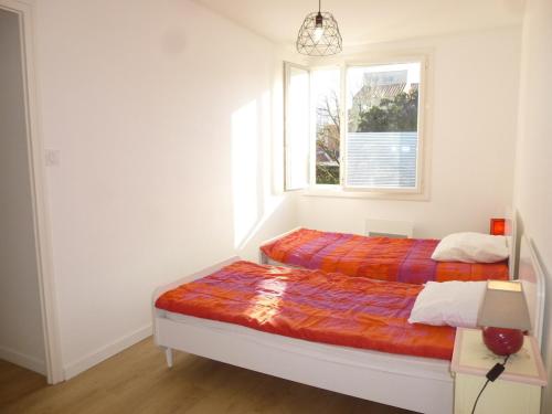 une chambre avec deux lits et une fenêtre dans l'établissement Maison refaite à neuf proche plage, 3 pièces, 6 couchages, jardin privé, parking inclus - FR-1-224C-156, à Saint-Jean-de-Monts