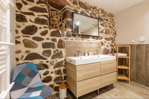 a bathroom with a stone wall with a sink at Le Rétro à Kaysersberg in Kaysersberg